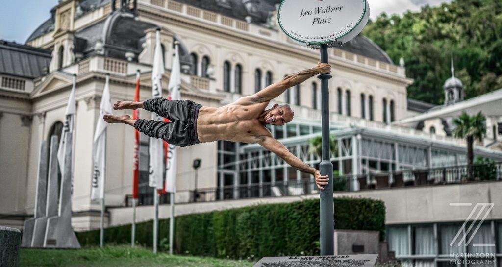 Mann hängt an einem Schild wie eine Flagge im Freien