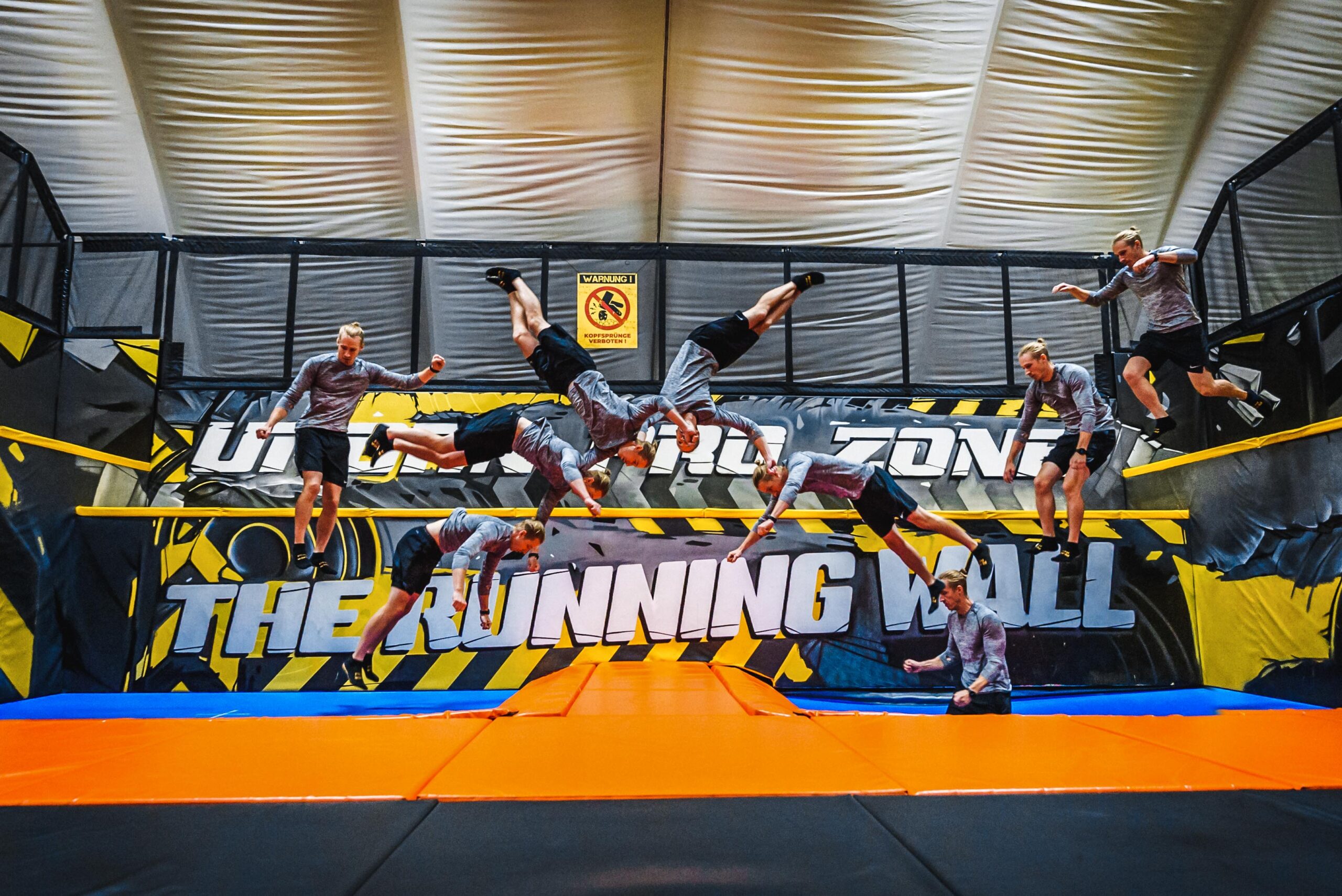 Person führt einen Sprung von der Running Wall im Jumpin Warrior Indoor Abenteuerpark aus