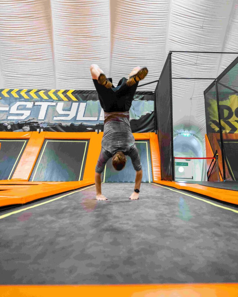 Mann im Handstand auf einem Trampolin im Jumpin Warrior Park SCS Vösendorf