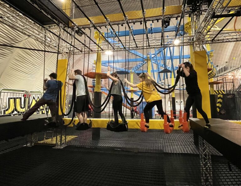 Schülergruppe im Trampolinpark Jumpin Warrior in SCS Vösendorf beim Überqueren eines Hindernisses.